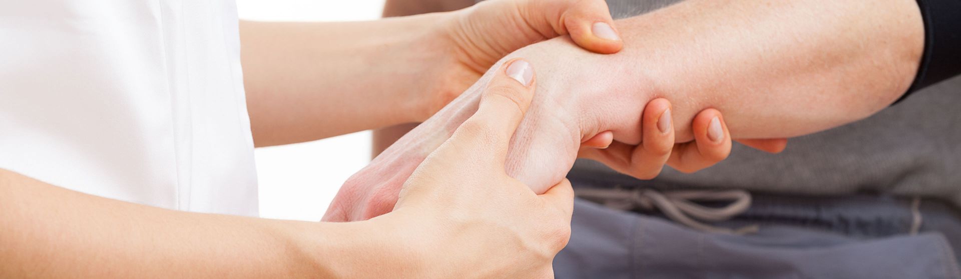 Ergotherapeutin behandelt die Hand eines Patienten.