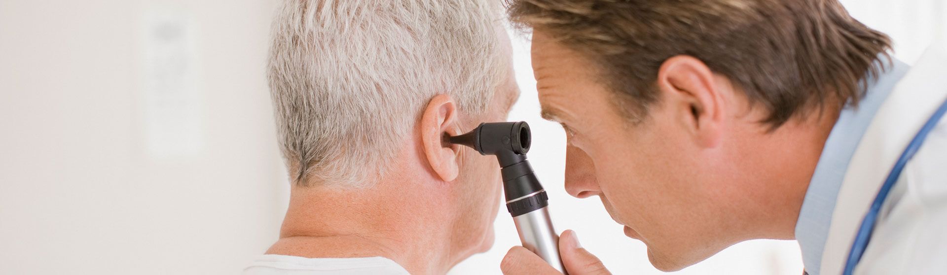 HNO-Arzt untersucht das Ohr eines Patienten.