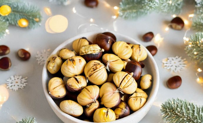 Schüssel mit Maroni auf weihnachtlich dekoriertem Tisch.