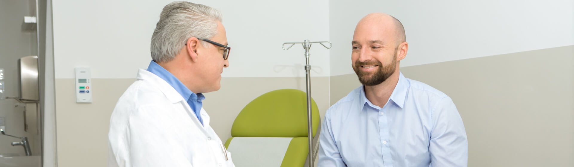 Urologe führt mit einem Patienten ein Gespräch in seiner Ordination.