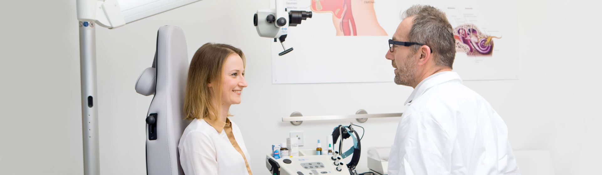 HNO-Arzt führt in seiner Ordination ein Gespräch mit einer Patientin.