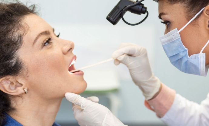 HNO-Ärztin untersucht den Hals einer Patientin.