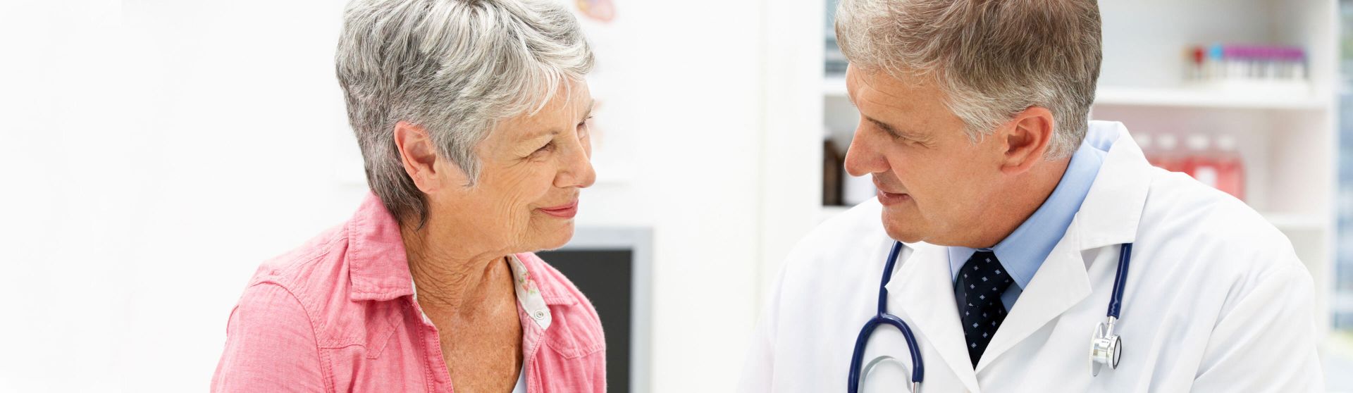 Neurologe führt ein Gespräch mit einer älteren Patientin.