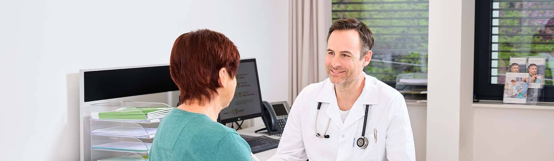Arzt führt mit einer Patientin ein Gespräch im Gesundheitszentrum für Selbständige.