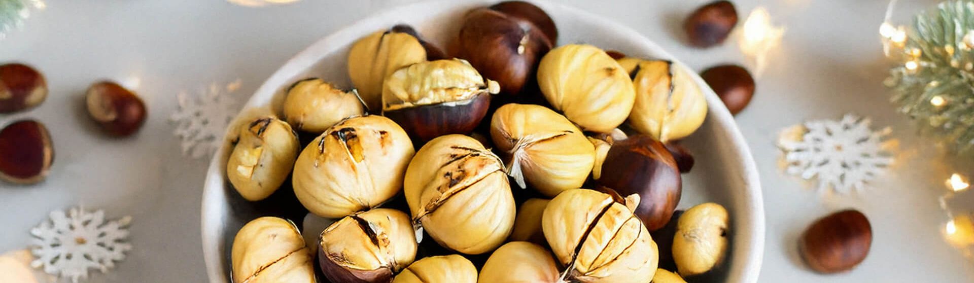 Schüssel mit Maroni auf weihnachtlich dekoriertem Tisch.